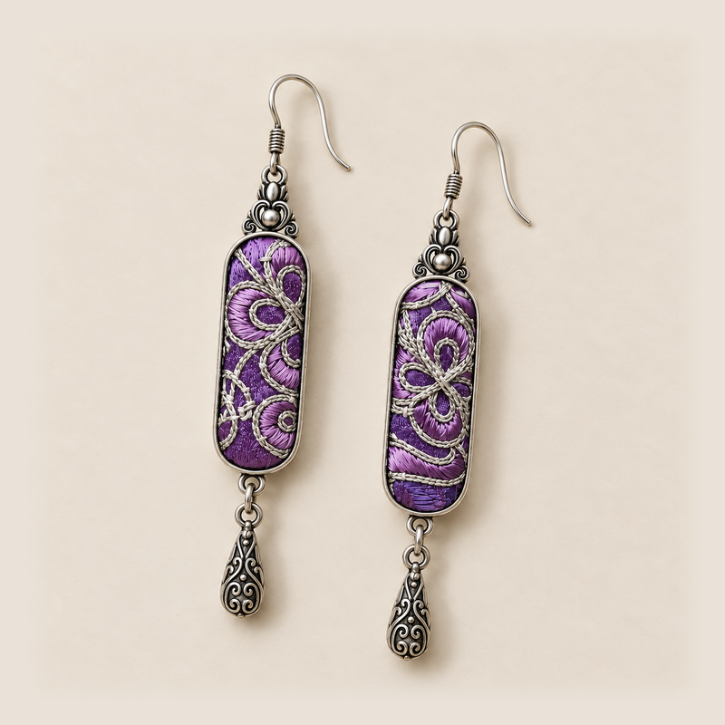Front detail of Violet Luminance earrings showing different pale couched outlines over purple stitched panels.