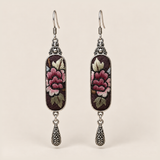 Petal Nocturne Suzhou Embroidery earrings featuring rose-pink petals and pale, olive-toned foliage on dark textile, with one engraved teardrop each.