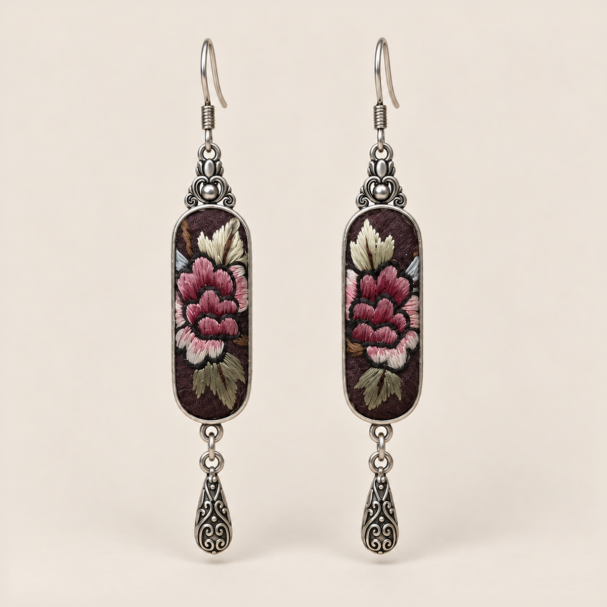 Petal Nocturne Suzhou Embroidery earrings featuring rose-pink petals and pale, olive-toned foliage on dark textile, with one engraved teardrop each.