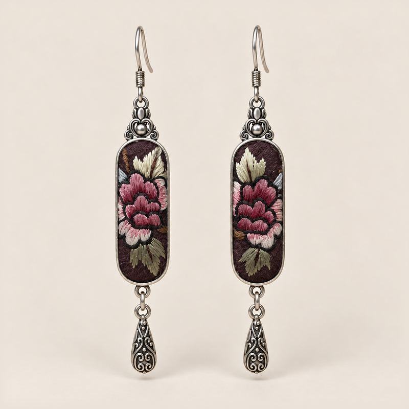 Petal Nocturne Suzhou Embroidery earrings featuring rose-pink petals and pale, olive-toned foliage on dark textile, with one engraved teardrop each.