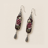 Front detail of Petal Nocturne earrings showing layered rose-pink petals and pale, olive-toned leaves on dark panels.