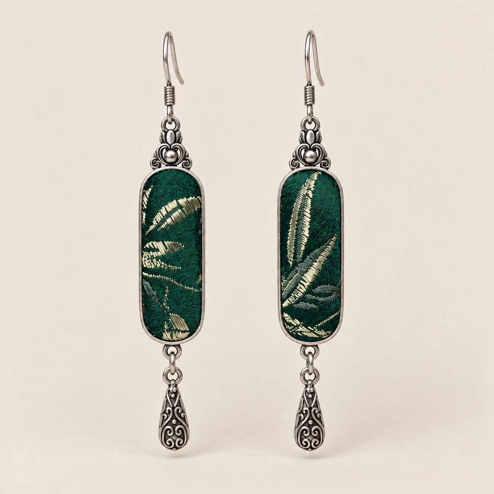 Emerald Reverie Song Brocade earrings with pale leaf-like woven motifs on green panels and one engraved teardrop each.