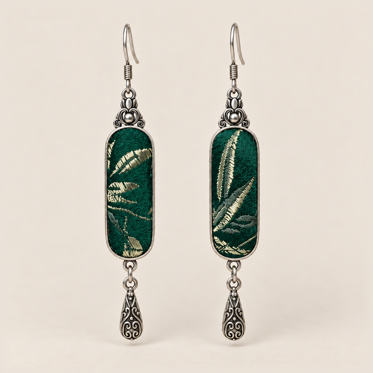 Emerald Reverie Song Brocade earrings with pale leaf-like woven motifs on green panels and one engraved teardrop each.