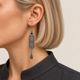 Emerald Reverie earring worn with its scrollwork reverse and central oval motif facing outward above one teardrop.