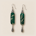 Front detail of Emerald Reverie earrings showing different pale leaf-like patterns woven into green textile panels.