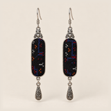 Ember Constellation Counted-Thread Embroidery earrings with navy, red, orange and white stitches on black panels and engraved drops.