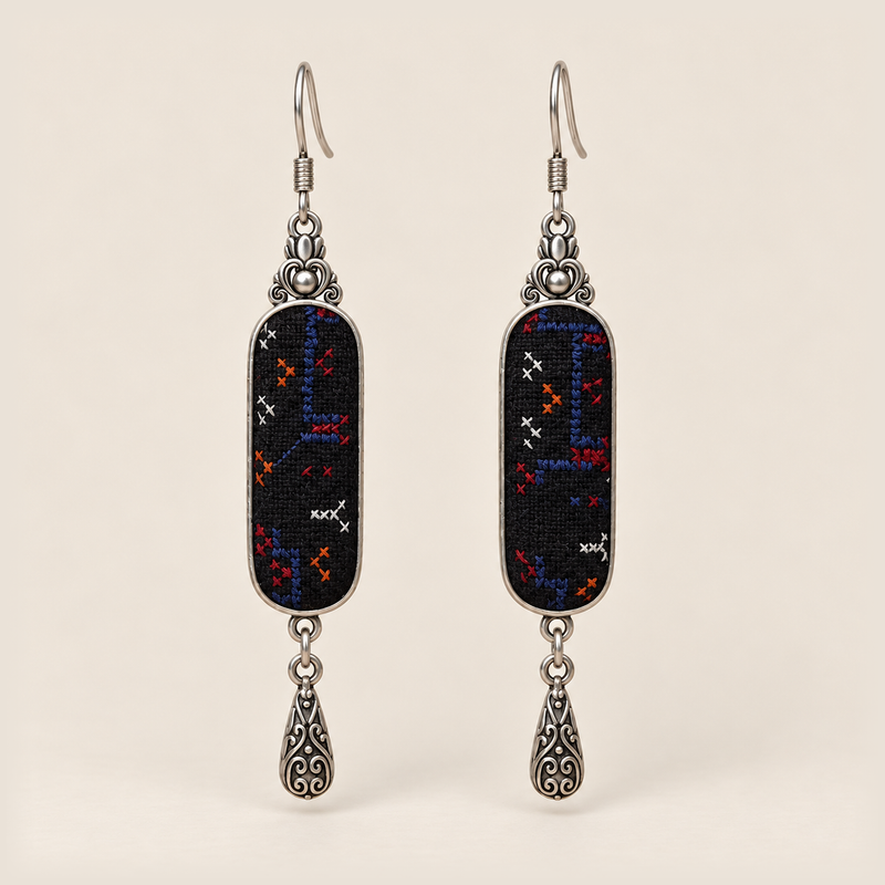 Ember Constellation Counted-Thread Embroidery earrings with navy, red, orange and white stitches on black panels and engraved drops.