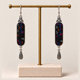 Ember Constellation earrings hanging from a gold-toned display stand with a pale rectangular base.