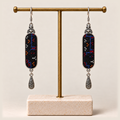 Ember Constellation earrings hanging from a gold-toned display stand with a pale rectangular base.