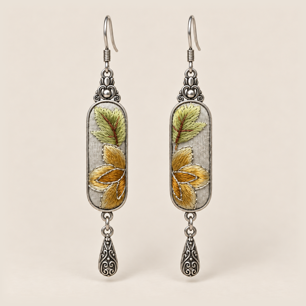 Autumn Sonata Suzhou Embroidery earrings with yellow-green leaves and ochre petals on pale gray panels, each with an engraved drop.