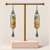Autumn Sonata earrings hanging from a gold-toned display stand with a pale rectangular base.