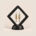 Autumn Sonata earrings displayed inside a black diamond-shaped frame on a rounded black base.