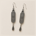 Reverse of the Blue Reverie pair, showing curled metal relief, central oval motifs and one engraved teardrop per earring.