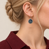 Close-up of an Indigo Cosmos earring worn with pale batik curves on its indigo circular front facing outward.
