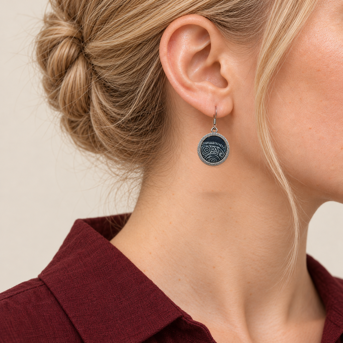 Close-up of an Indigo Cosmos earring worn with pale batik curves on its indigo circular front facing outward.