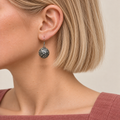 Petal Mosaic earring worn with the rounded metal reverse and raised scrollwork facing outward.