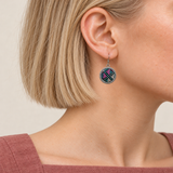 Petal Mosaic earring worn with pink, teal and pale geometric embroidery on its dark circular front facing outward.