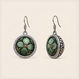 Verdant Bloom round earrings with green embroidered petals, gold-colored details, geometric rims and domed scrollwork backs.