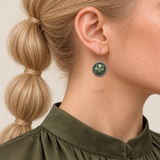 Verdant Bloom earring worn with green embroidered petals and a gold-colored center facing outward.
