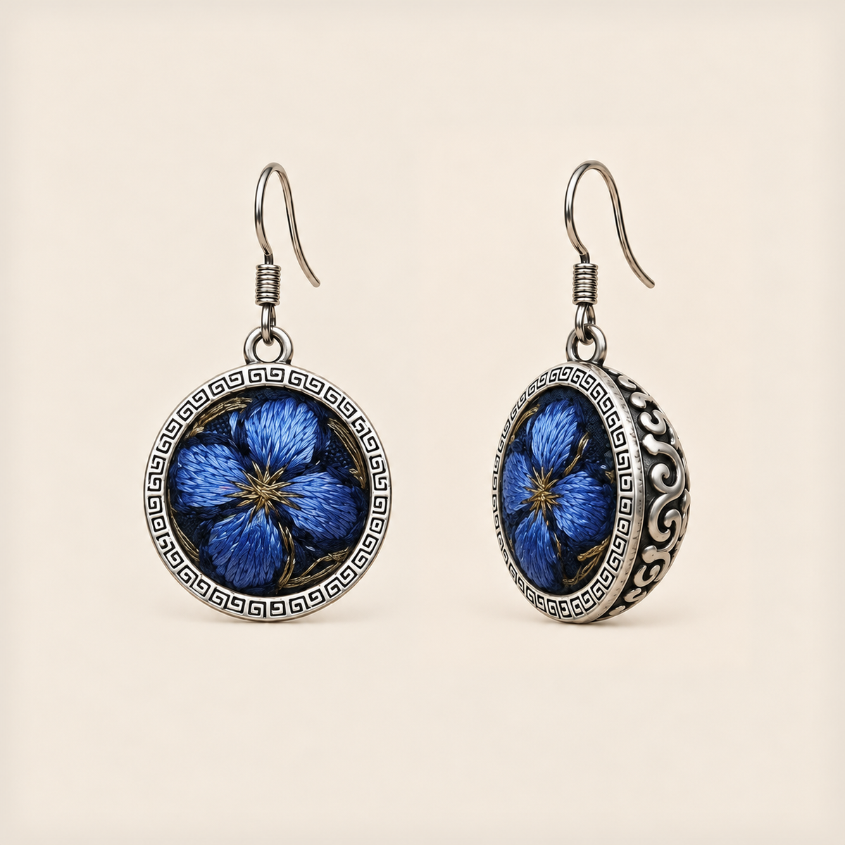 Sapphire Reverie round earrings with blue embroidered petals, gold-colored details, geometric rims and domed scrollwork backs.
