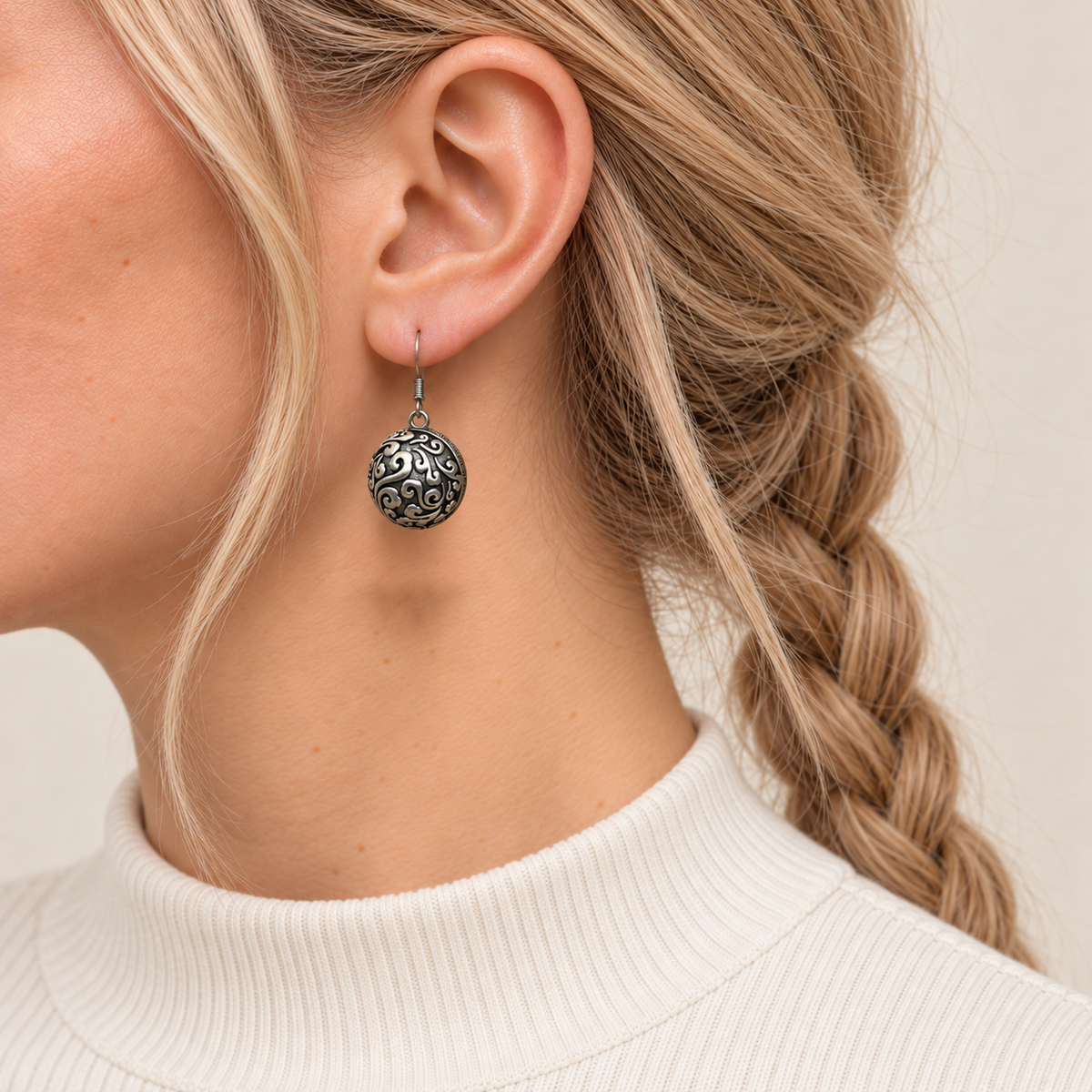Sapphire Reverie earring worn with the rounded metal reverse and raised scrollwork facing outward.