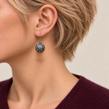 Jade Arabesque earring worn with the rounded metal reverse and raised scrollwork facing outward.