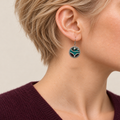 Jade Arabesque earring worn with pale raised outlines around teal and burgundy embroidered sections facing outward.