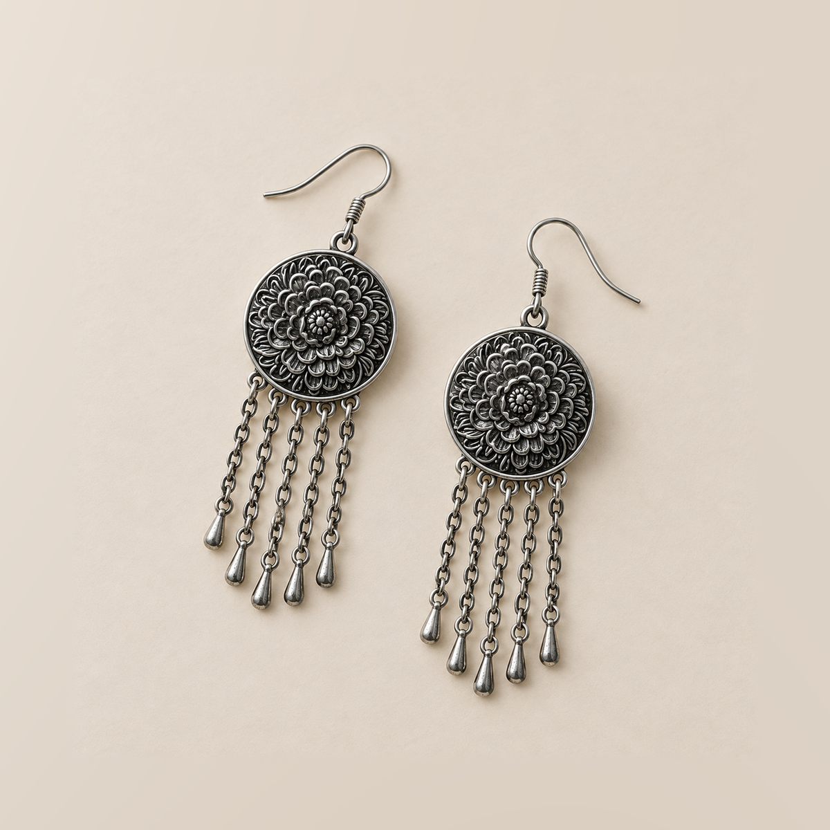 Indigo Canticle earrings laid back-facing, showing layered flower relief on the round metal backs and five chain tassels on each.