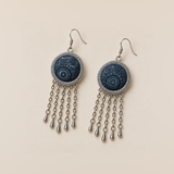 Indigo Canticle earrings laid front-facing, showing pale radial batik motifs on indigo fabric and five chains with teardrop ends on each.