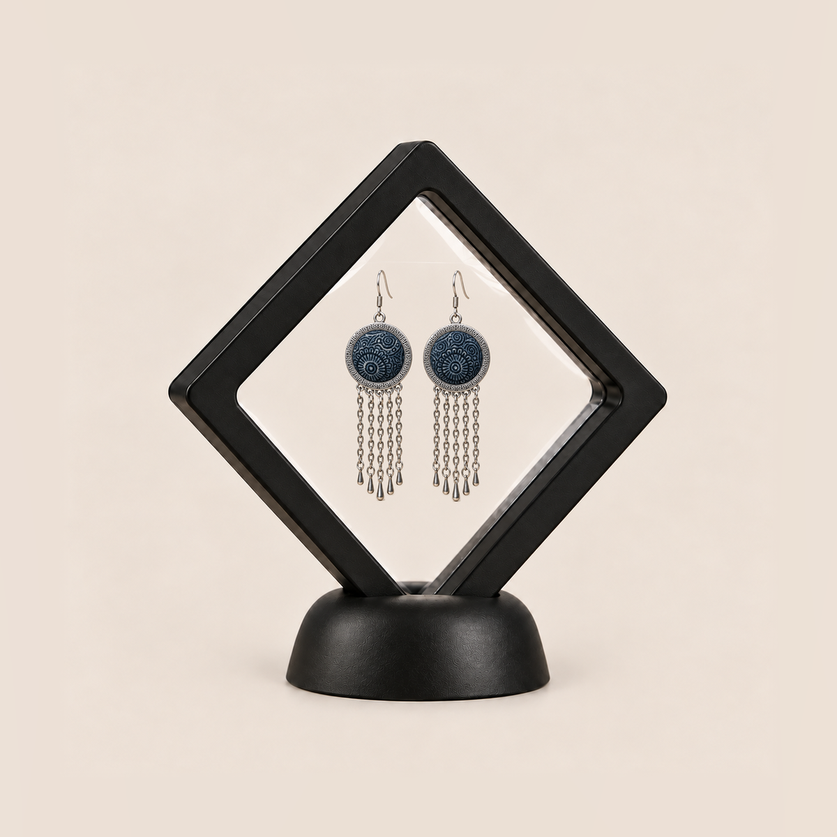 Indigo Canticle earrings displayed inside a clear membrane in a black square frame set diagonally on a black base.