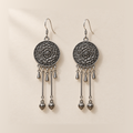 Amber Floraison earrings laid back-facing, showing flower relief on the round medallions, three short drops and two long rods with bud pendants on each.