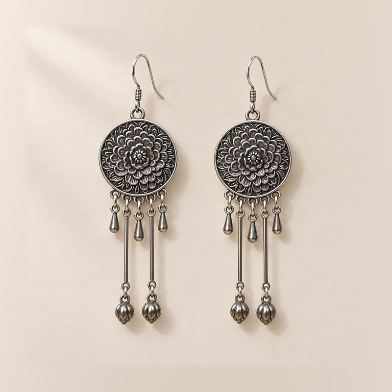 Amber Floraison earrings laid back-facing, showing flower relief on the round medallions, three short drops and two long rods with bud pendants on each.