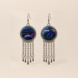 Violet Undertow earrings with blue, violet and dark curved embroidered bands in round patterned frames, each with five linked tassels and teardrop ends.