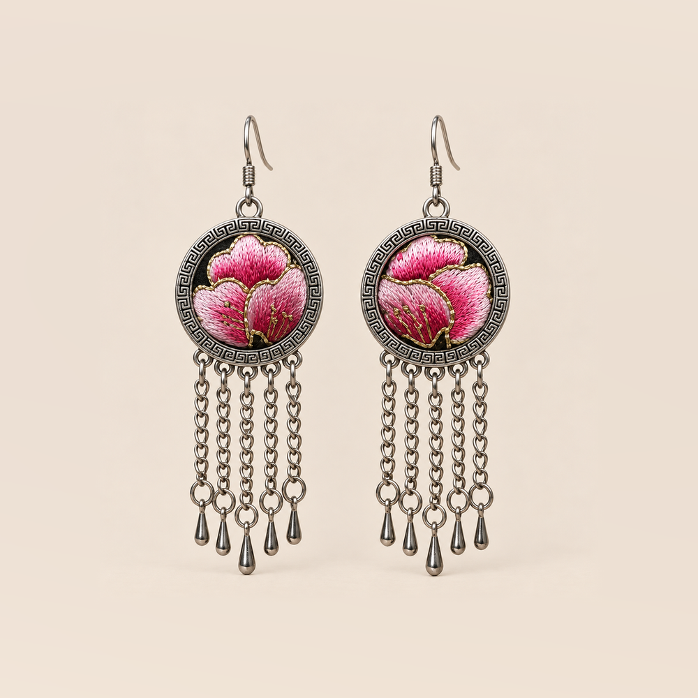 Blush Rhapsody earrings with pink embroidered petals and gold-colored stitched edges on dark round fronts, each with five chain tassels and teardrop ends.