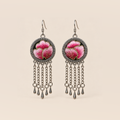Blush Rhapsody earrings with pink embroidered petals and gold-colored stitched edges on dark round fronts, each with five chain tassels and teardrop ends.