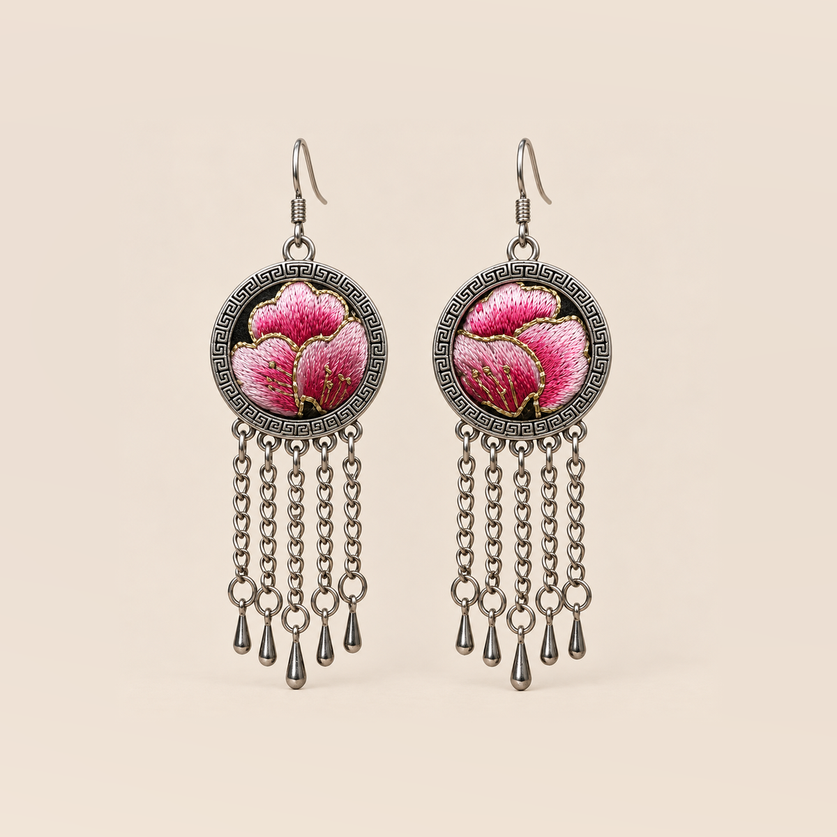 Blush Rhapsody earrings with pink embroidered petals and gold-colored stitched edges on dark round fronts, each with five chain tassels and teardrop ends.