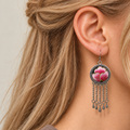 Close profile of a model wearing Blush Rhapsody with pink Suzhou embroidered petals and gold-colored stitched edges facing outward above five chain tassels.