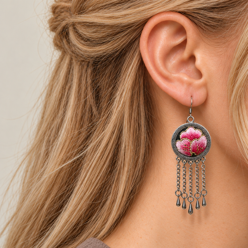 Close profile of a model wearing Blush Rhapsody with pink Suzhou embroidered petals and gold-colored stitched edges facing outward above five chain tassels.