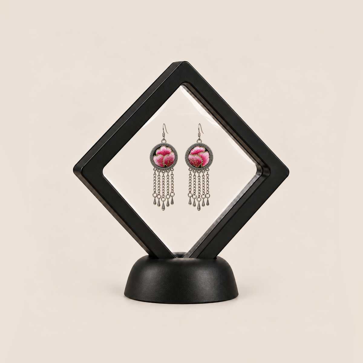 Blush Rhapsody pair displayed in a black square clear-membrane frame on a black stand, with both pink embroidered fronts facing forward.