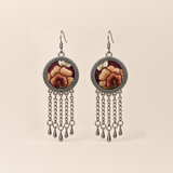 Garnet Serenade earrings with ochre, brown-gold and cream embroidered petals on wine-red round fronts, each with five chain tassels and teardrop pendants.