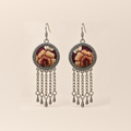 Garnet Serenade earrings with ochre, brown-gold and cream embroidered petals on wine-red round fronts, each with five chain tassels and teardrop pendants.
