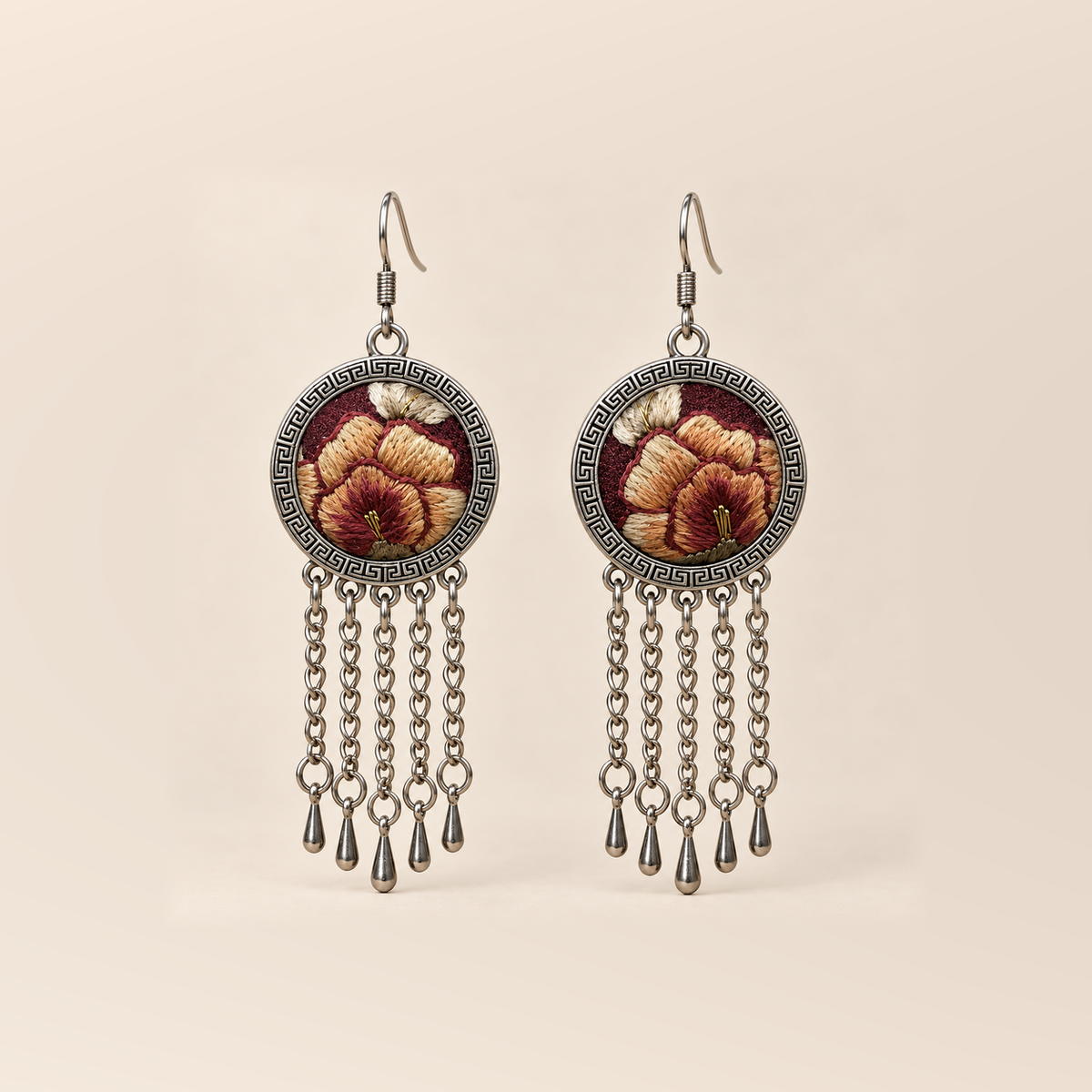 Garnet Serenade earrings with ochre, brown-gold and cream embroidered petals on wine-red round fronts, each with five chain tassels and teardrop pendants.