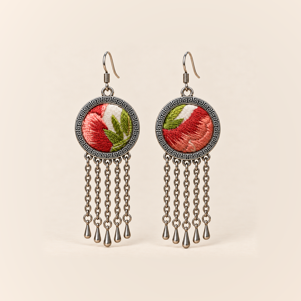Coral Reverie earrings with coral-red and pink embroidered petals and green leaves on ivory-colored round fronts, each with five oval-link chains and teardrop ends.