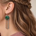Verdant Concord earring worn at the ear, showing emerald woven Song Brocade, pale diagonal forms, gold-olive bands and hanging chains.