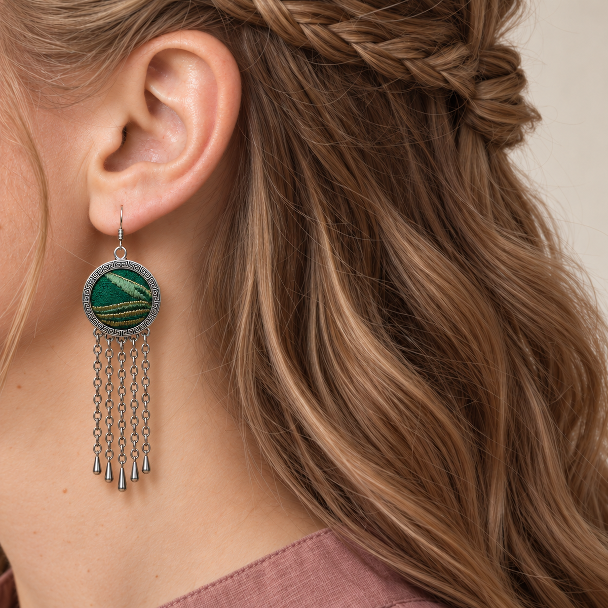 Verdant Concord earring worn at the ear, showing emerald woven Song Brocade, pale diagonal forms, gold-olive bands and hanging chains.
