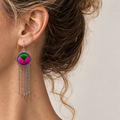 Rose Chorus earring worn at the ear, showing bold green and pink textured embroidery, a patterned rim and five long chains with teardrops.