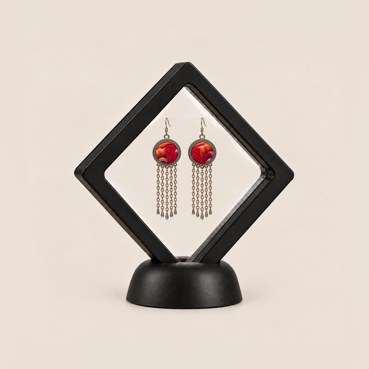 Ember Refrain earrings displayed in a tilted black square membrane frame on a round black base.