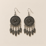 Pair of Garden Murmur floral metal reverses on cream cloth, each with five short connecting chains and flat veined leaf pendants.