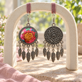 Garden Murmur embroidered front and floral reverse hanging from pink fabric loops on a cream arch, with five leaf pendants each.