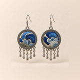 Azure Harmony Three-Blue Embroidery earrings with deep and pale blue floral curves on ivory-colored cloth, patterned rims and five short teardrop pendants.